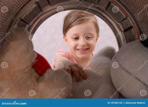 A Man Takes Clean Underwear From The Drum Of The Washing Machine A