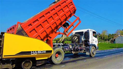 Asphalt Paving Dump Trucks Laying The 1st Hot Mix Layer On The Road