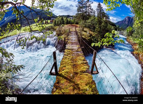 Suspension bridge over the mountain river. Beautiful Nature Norway natural landscape. Fisheye ...