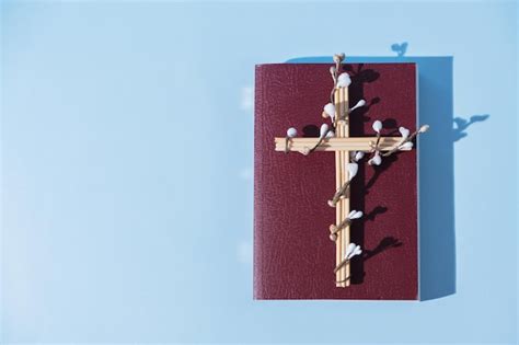 Premium Photo Cross Decorated Flowers With Holy Bible On Blue