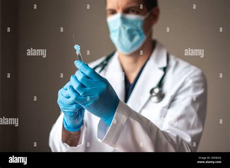 Doctor In White Coat Holding Syringe With Vaccine Ready For Injection