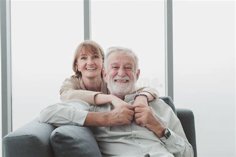 Retrato Do Casal S Nior Sentado No Sof E Se Abra Ando Juntos Foto De