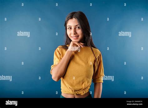 Happy Brunette Woman Wearing Casual Top Isolated Over Blue Background