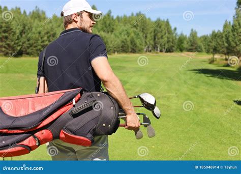 Golf Player Walking And Carrying Bag On Course During Summer Game