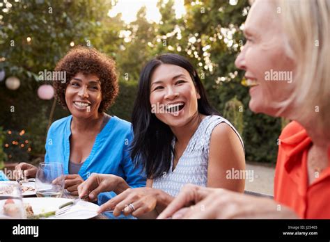 Mature Female Friends Enjoying Outdoor Meal In Backyard Stock Photo Alamy