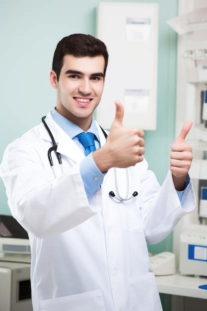 Retrato de un joven médico que muestra el pulgar hacia arriba mientras