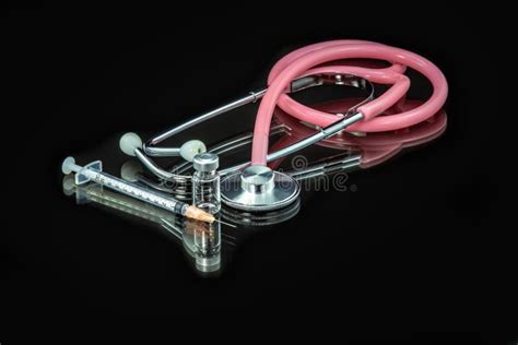 Pink Stethoscope Syringe And Bottle Of Medicine On A Black Background