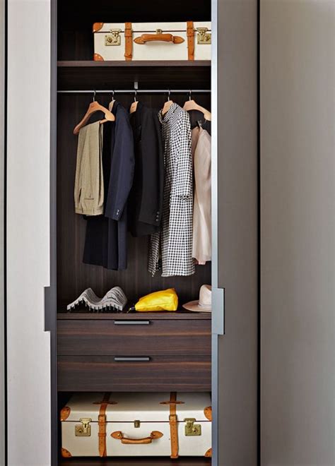 An Open Closet With Clothes And Suitcases