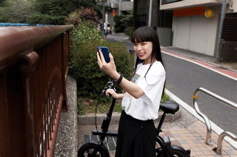 Free Photo Woman Riding Bicycle In The City And Taking Selfie