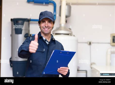 Smiling Technician Servicing A Hot Water Heater Stock Photo Alamy