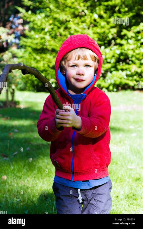 Young Boy Playing Outdoors With A Stick Stock Photo Alamy