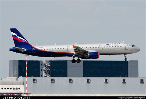 An Airplane Is Taking Off From The Runway In Front Of Some Buildings