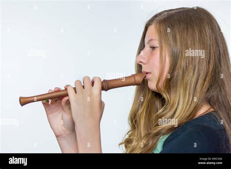 Caucasian teenage girl blonde avec de longs cheveux blonds jouer de la flûte isolé sur fond