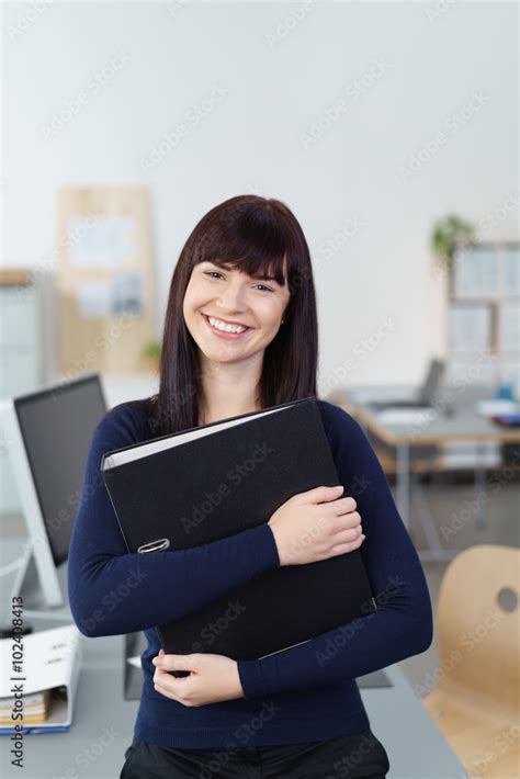 junge geschäftsfrau im büro trägt einen aktenordner Stock Foto Adobe