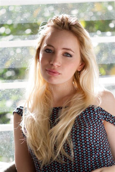 A Sensual Blonde Holding Her Hair Lighted By The Sun Stock Photo Image Of Blue Indoors