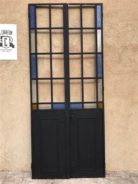 A Black Double Door With Stained Glass Panels On The Side Of A Building