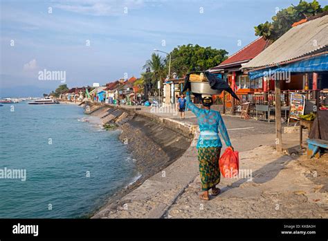 Indonesian Woman Carrying Merchandise On Her Head In The Coastal