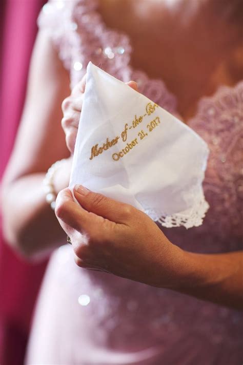 A Woman In A Pink Dress Holding A White Napkin With The Words Mother Of