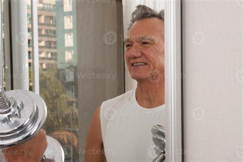 Mature Man Plus Working Out With Weights At Home In Front Of A Mirror