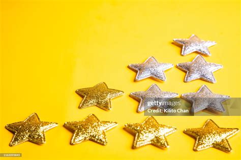 A Group Of Golden And Silver Stars Against Yellow Background High Res