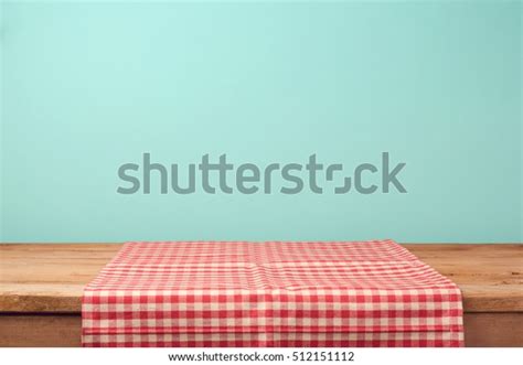 Empty Wooden Deck Table And Red Checked Tablecloth Over Mint Wallpaper