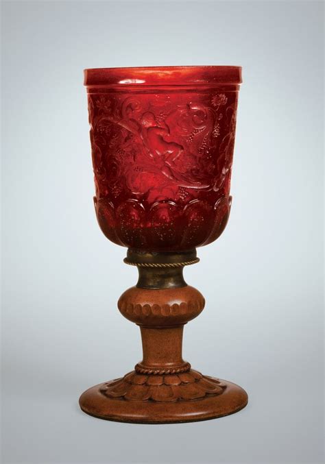 A Red Glass Sitting On Top Of A Wooden Stand