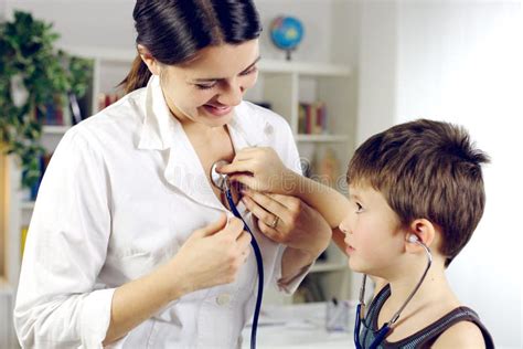 Child Playing With Stethoscope On Female Happy Doctor Stock Image