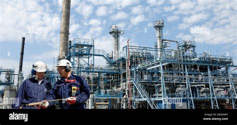 Oil And Gas Workers With Refinery In Background Stock Photo Alamy