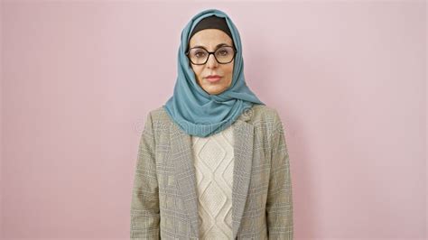 Portrait Of A Mature Woman With Hijab And Glasses Against A Pink