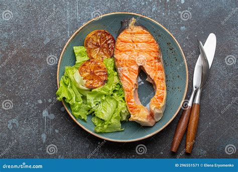 Grilled Fish Salmon Steak And Green Salad With Lemon On Ceramic Plate