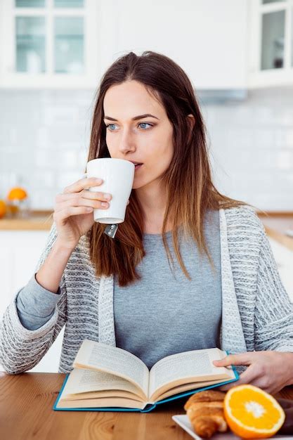 Free Photo Woman Drinking While Reading Book