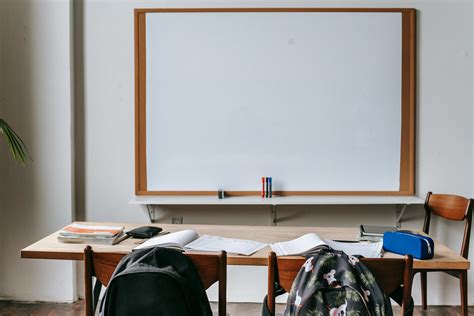 Classroom with whiteboard and desk with stationery · Free Stock Photo