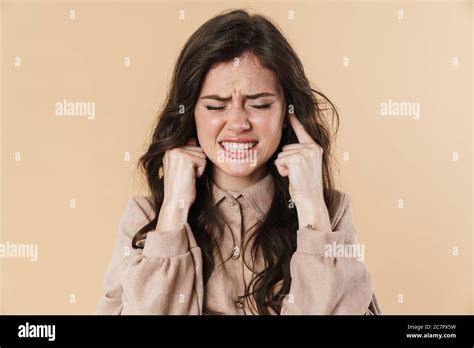 Image Of Unhappy Brunette Nice Woman Plugging Her Ears Isolated Over Beige Background Stock