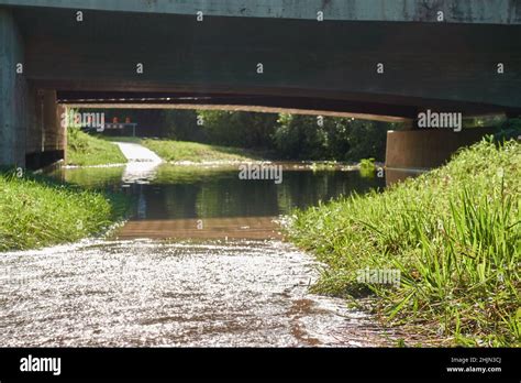 Flooded Road After Heavy Rain Water Overflows The River Bank And Backs