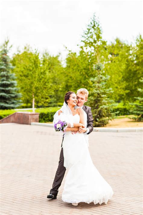 Pares Hermosos De La Boda En Parque Beso Y Abrazo Foto De Archivo