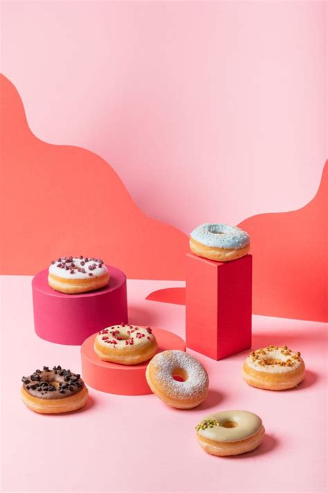 Several Donuts Are Arranged In Different Colors On A Pink And Pink