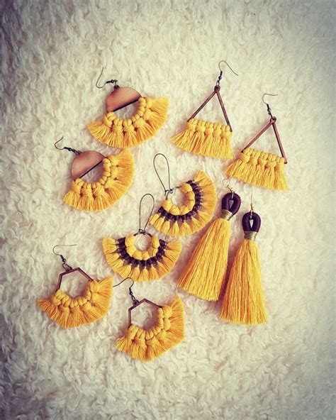 Six Pairs Of Yellow Tasseled Earrings On White Furnishing With Wooden Beads