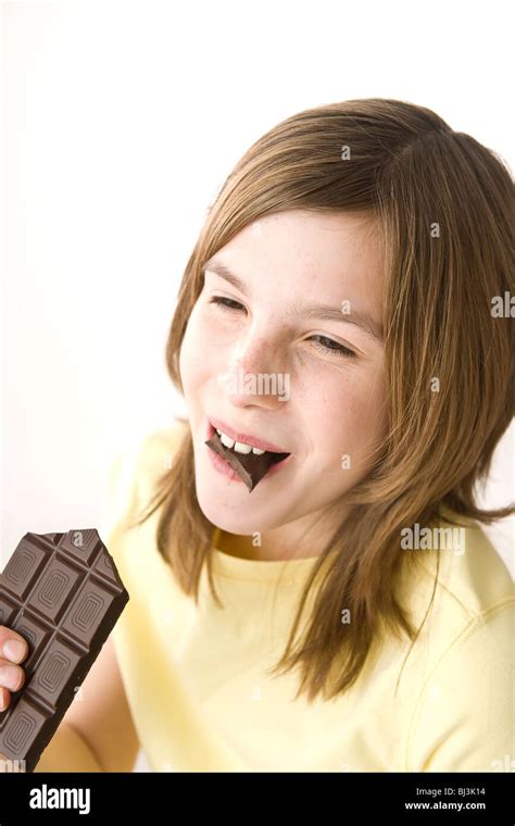 Girl Biting Into A Chocolate Bar With Pleasure Stock Photo Alamy