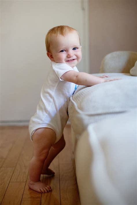 Baby Standing Up Against A Couch Stock Image Image Of Happiness