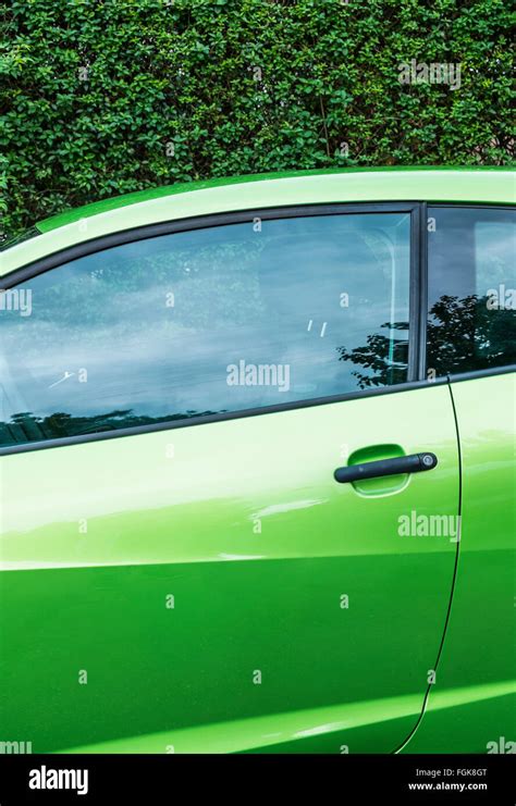 green car against dark green hedge Stock Photo - Alamy