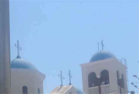 Two White Buildings With Blue Domes And Crosses On The Top Against A