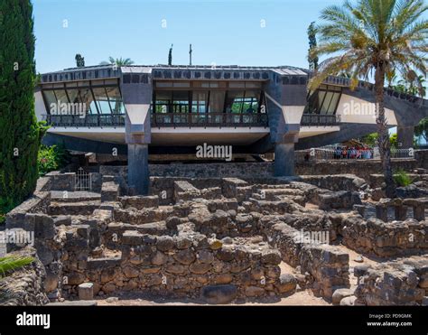 Capernaum, Israel May 18 2018:Modern church over the ruins of the dark basalt rock village of ...