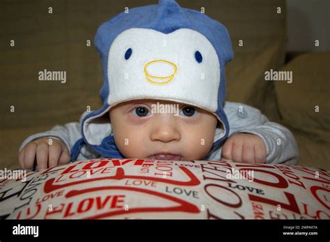 Image Of An Adorable Newborn Baby Resting His Head On A Pillow While