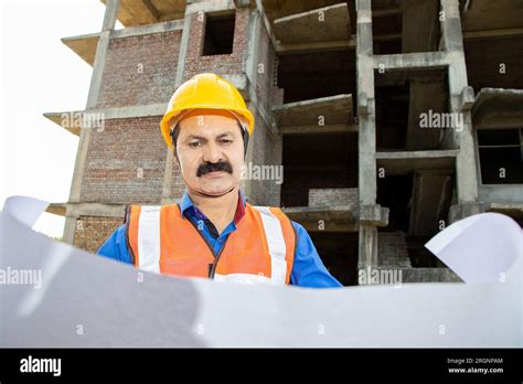 Mature Indian Male Civil Engineer Or Architect Wearing Helmet And Vest