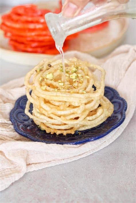 Someone Is Pouring Something Into Some Food On A Blue Plate With Red