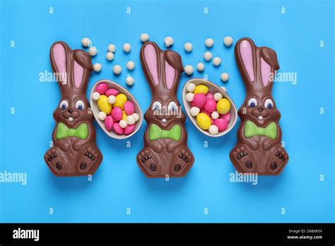 Chocolate Easter Bunnies Halves Of Egg And Candies On Light Blue Background Flat Lay Stock