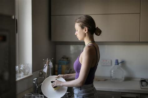 Mujer Lavando Los Platos En Casa Foto Gratis