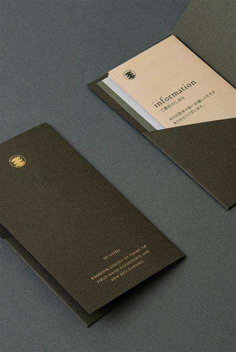 Two Business Cards On Top Of Each Other One With A Gold And White Logo