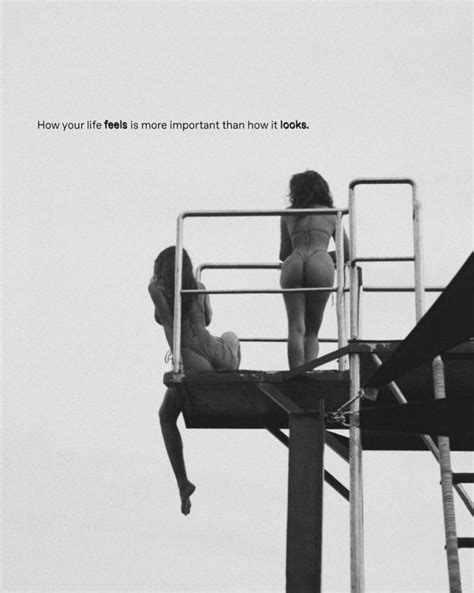 Two Women Are Sitting On The Top Of A Life Guard Tower