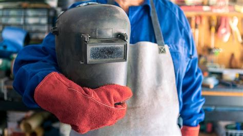 Un homme soudeur avec casque de sécurité travaillant avec une machine à